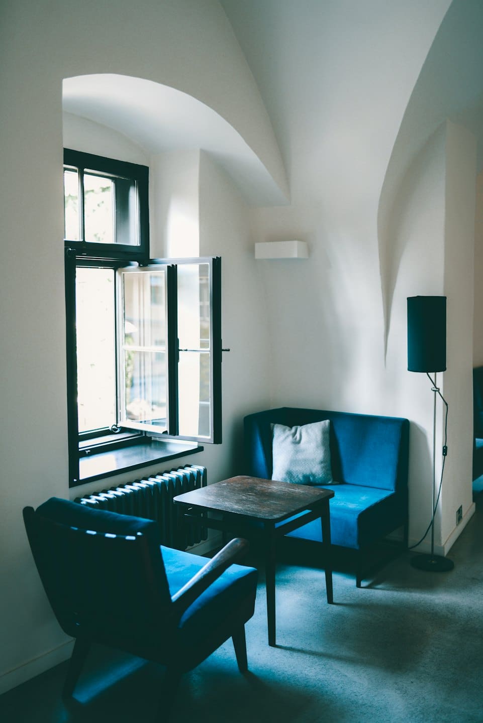 Sedute blu scuro disposte attorno a un tavolo di legno in un ufficio.